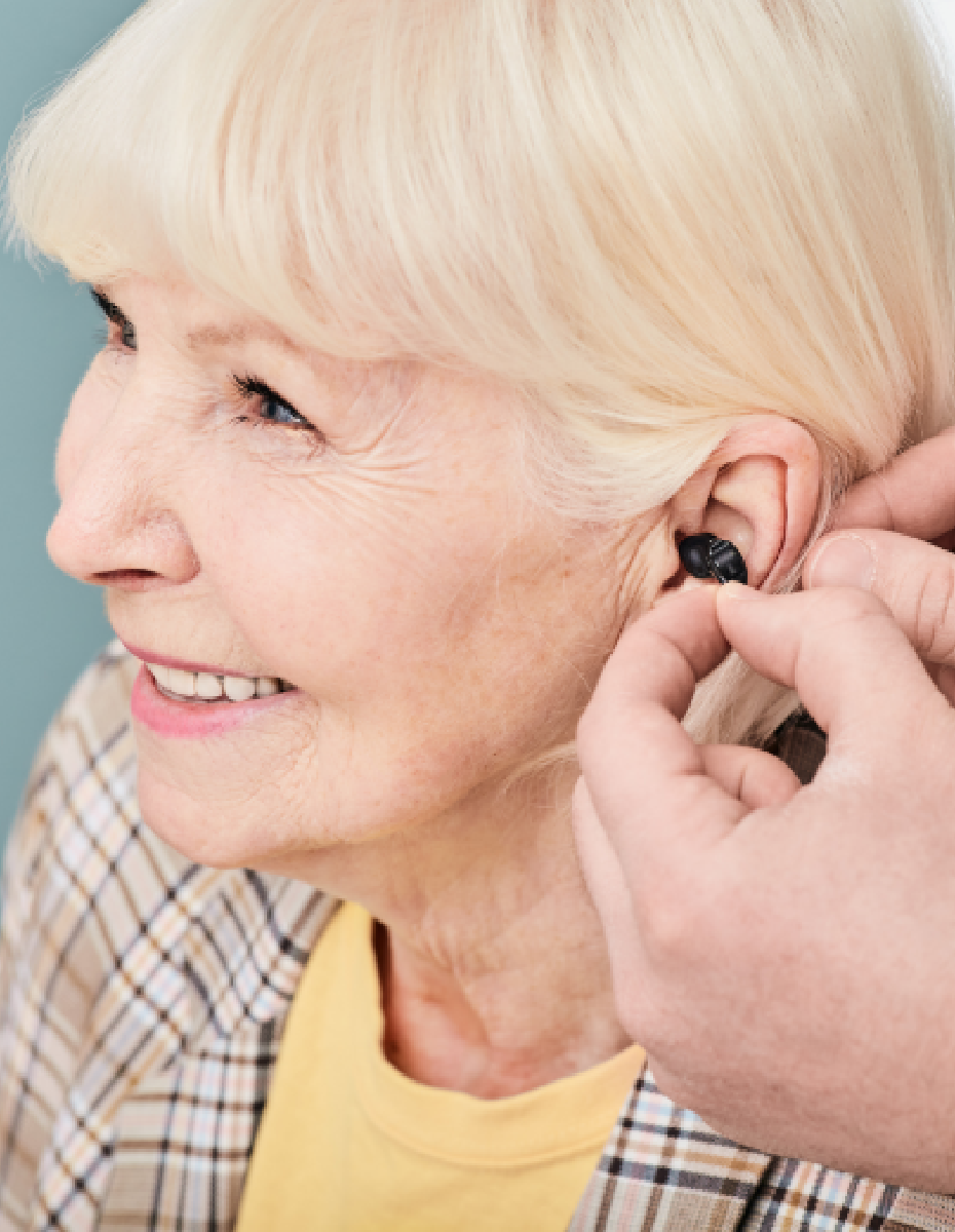 Frau bekommt Hörgerät eingesetzt. 