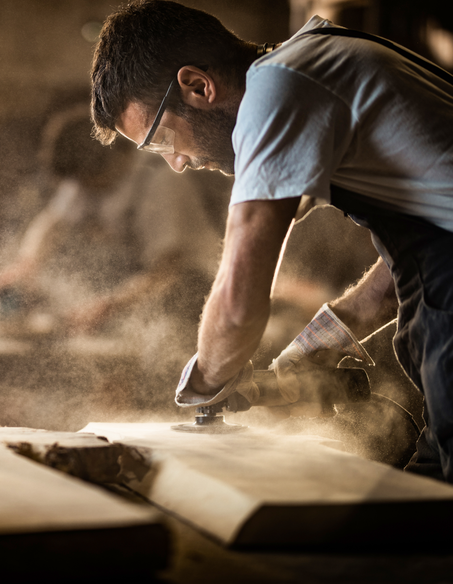 Handwerker beim Sägen einer großen Holzplatte.